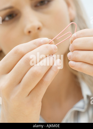 Woman looking at paperclip Stock Photo