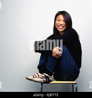 Portrait of a young woman sat on a chair Stock Photo