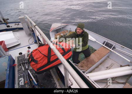 Loading equipment into a skiff in the Aleutian Islands in Alaska Stock Photo