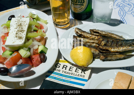 Outdoor al fresco Greek taverna meal Greek salad grilled sardines cold beer Skiathos Island Sporades Greece Stock Photo