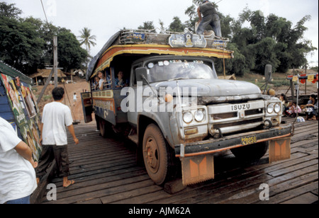 A tourist looks out from a truck bus being ferried across a river near Champasak in southern Laos Stock Photo