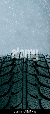 New winter tire against a blizzard background Stock Photo