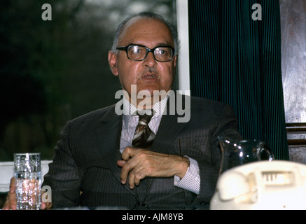 Businessman Sitting at Desk Holding Glass Of Water Stock Photo