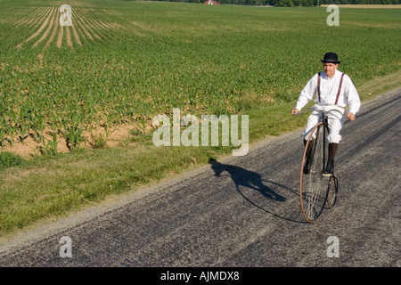 Man riding bicycle on rural road Stock Photo