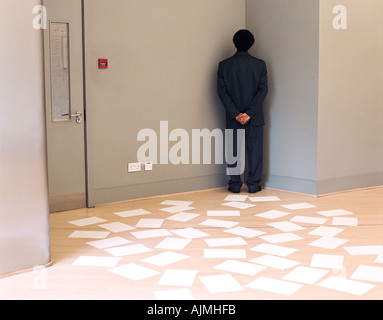 Businessman trapped by documents in office Stock Photo