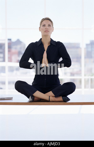 Woman meditating on her desk Stock Photo