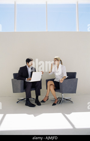 Colleagues using mobile and laptop Stock Photo