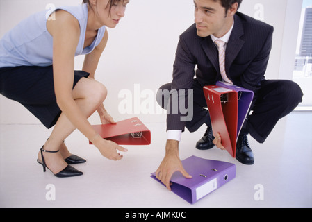 Businessman picking up folders for colleague Stock Photo