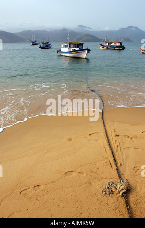 A fishing boat tied to mainland with a rope in Praia Japariz beach, Ilha Grande, Brazil Stock Photo