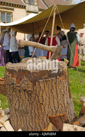 Axe in a block of wood shown during medieval feasting Stock Photo