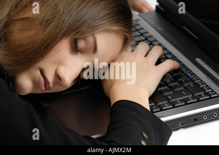 Young businesswoman sleeping on a computer keyboard Stock Photo