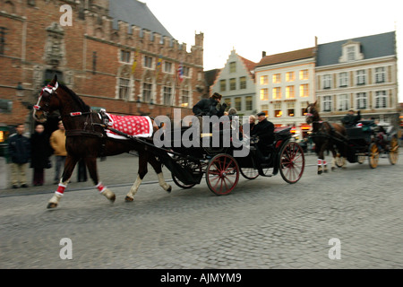 Tourists ride in a horse and carriage at Christmas. The Market Square, Bruges, Belgium. Stock Photo