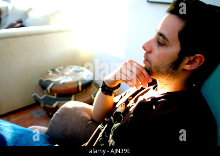 YOUNG MAN RELAXING AT HOME Stock Photo