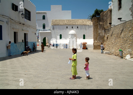 Two children in the square beside El Kamra Tower in the Medina, Asilah Stock Photo
