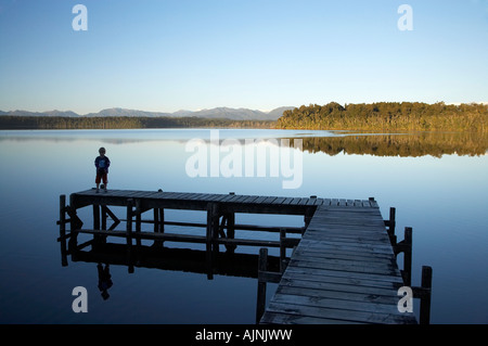 Small Boy on Jetty Lake Mahinapua near Hokitika West Coast South Island New Zealand Stock Photo