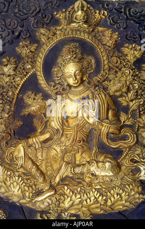 Golden statue of Green Tara peaceful tibetan buddhist female deity art. Ladakh, India. Stock Photo