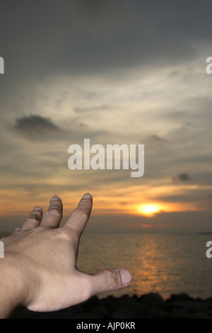 hand reaching out to the sun Stock Photo