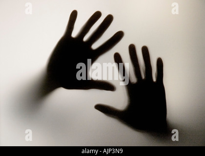 TWO HANDS ASKING SOS AND SEARCHING FOR HELP AGAINST GLASS Stock Photo