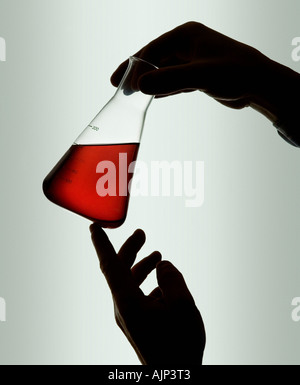 CHEMISTRY MEASURING BEAKER WITH RED LIQUID INSIDE. LAB WORKER Stock Photo