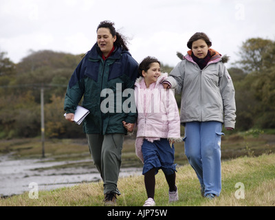 Mother and her two daughters taking a walk on a cold autumn day