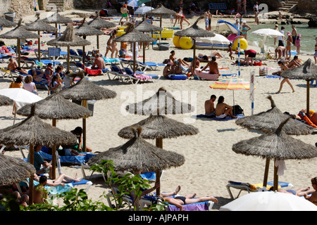Tourists and locals pack enjoy sun bath an Illetas beach in Palma de Mallorca, Spain Stock Photo