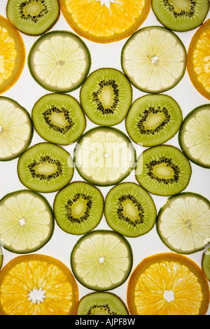 Assorted fruit slices arranged in pattern on white background Stock Photo