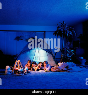 Girls sitting in a tent in the living room Stock Photo