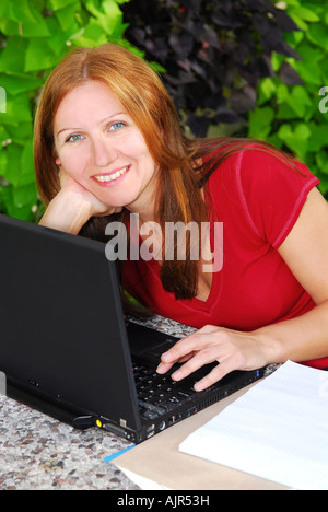 Happy mature woman working on portable computer at home small business owner Stock Photo