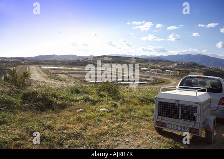 Car and Dog Trailer overlooking Mijas Hipodromo the horse racing track on Spains Costa del Sol Stock Photo