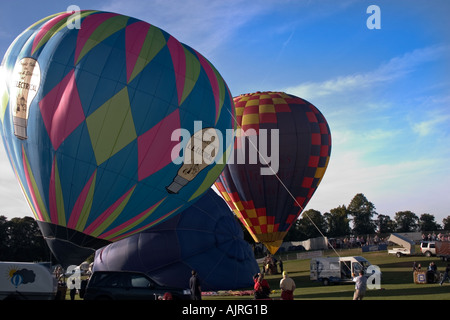 2 Inflating Balloons in field Stock Photo