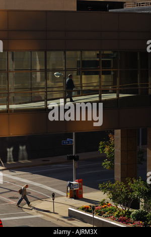 Pedestrians crossing a skywalk bridge over Grand Ave in Des Moines Iowa Stock Photo