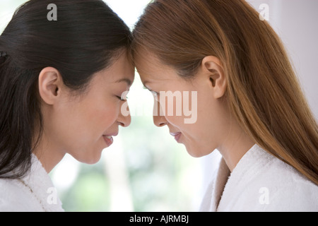 Side profile of two young women wearing bathrobes Stock Photo