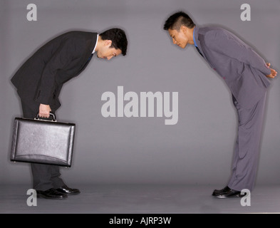 Side profile of two businessmen bowing Stock Photo