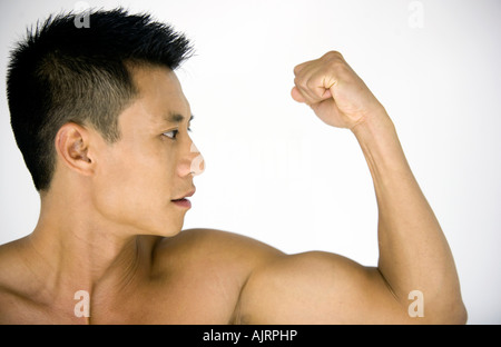 Close-up of a young man flexing his biceps Stock Photo
