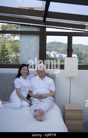 Portrait of a senior couple sitting on the bed Stock Photo