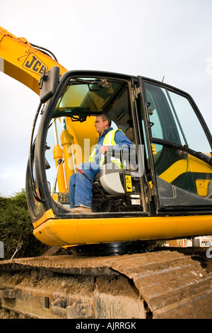 Excavator driver working on construction site digger demolishing ...