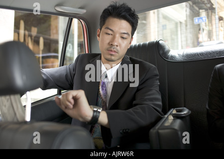 Close-up of a businessman sitting in a car and checking the time Stock Photo