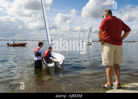 Learning to sail father watching instructor and son. Datchet Water Sailing Club, Queen Mother Reservoir, Slough Berkshire England. 2007 2000s Stock Photo