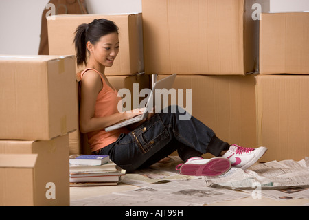 Side profile of a young woman sitting and using a laptop Stock Photo