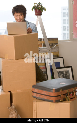 Young man standing and using a laptop Stock Photo