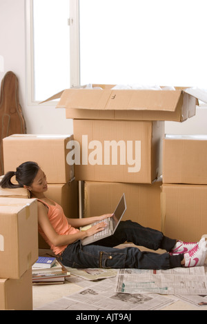 Side profile of a young woman sitting and using a laptop Stock Photo