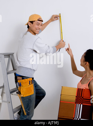 Young man looking at a young woman holding a painting Stock Photo