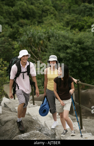 Two young women and a young man standing on steps Stock Photo