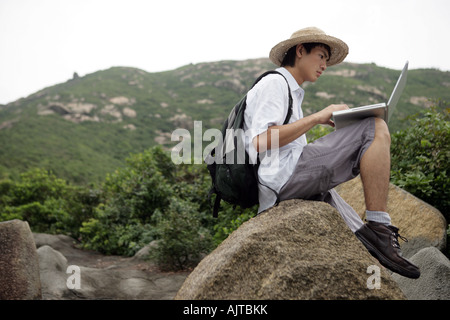 Side profile of a young man using a laptop Stock Photo