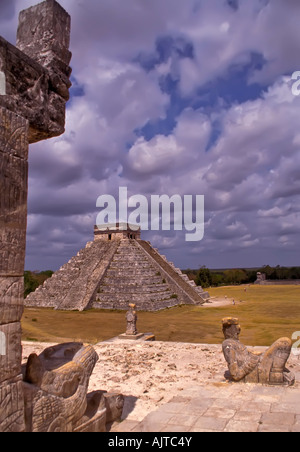 Chichen Itza Mexico pyramid the castle el castillo seen from temple of the warriors with serpent head in foreground Stock Photo