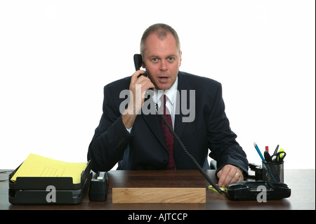 Businessman sat at his desk making a phone call Stock Photo