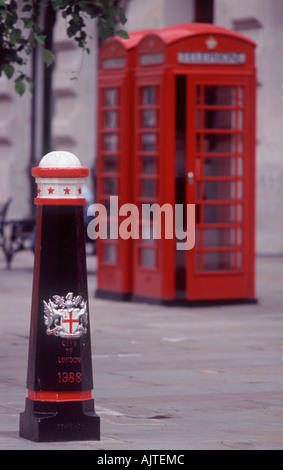 Red telephone box with ornamented traffic bollard with City of London crest in pedestrian precinct, City of London, England Stock Photo