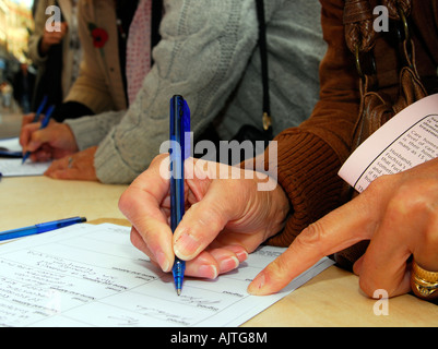 Members of the public signing a petition against cuts in mental health services, Kingston, Surrey, UK. Stock Photo