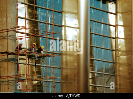 Workers taking a break and eating lunch against a modern office development, Beijing. Stock Photo