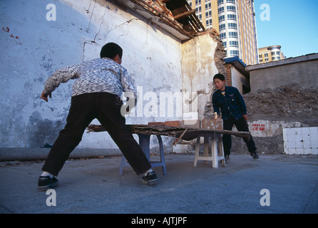 Pingong Boys kids playing with a make shift ping pong table in a hutong in central Beijing Stock Photo